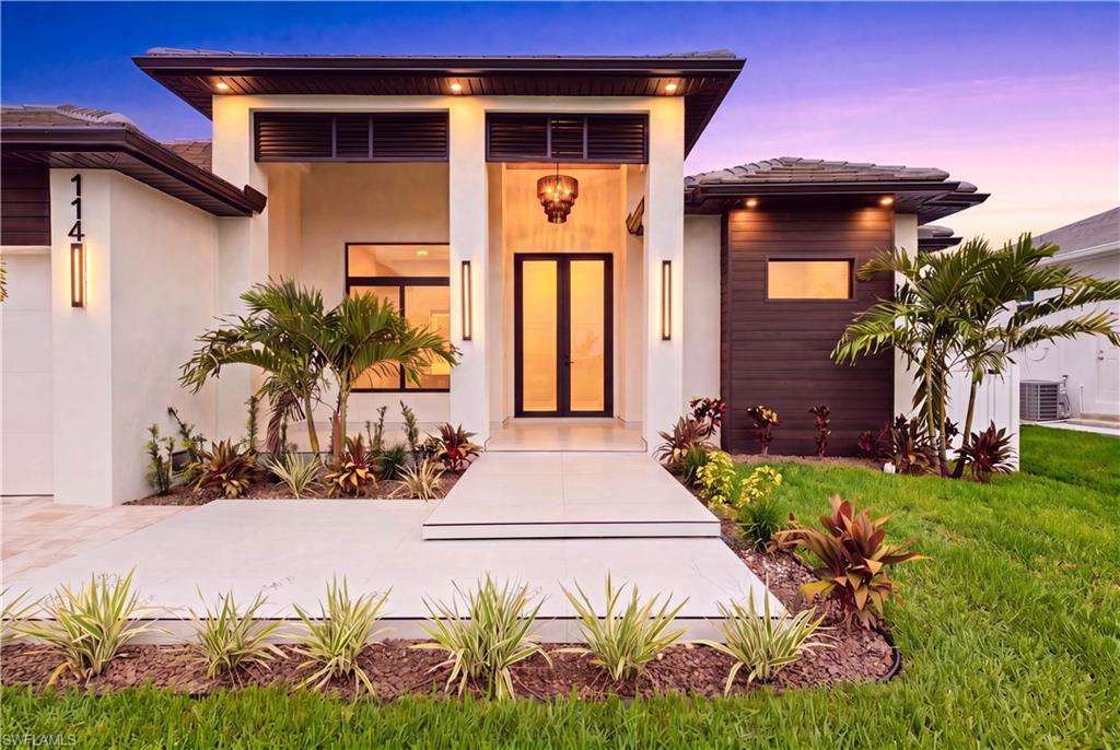 Elegant front elevation, designer landscaping, paver driveway, 3-car garage & striking covered entry w/ soaring columns, modern lighting & frosted double glass doors.