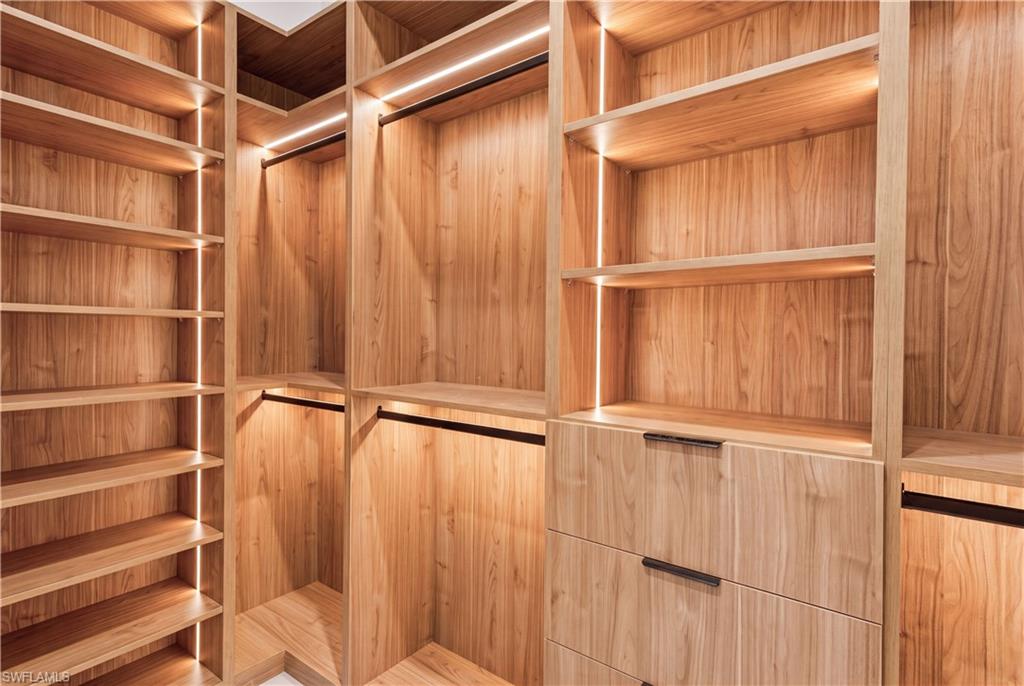 His-and-hers walk-in closets feature custom wood cabinetry, abundant shelving and generous hanging space.