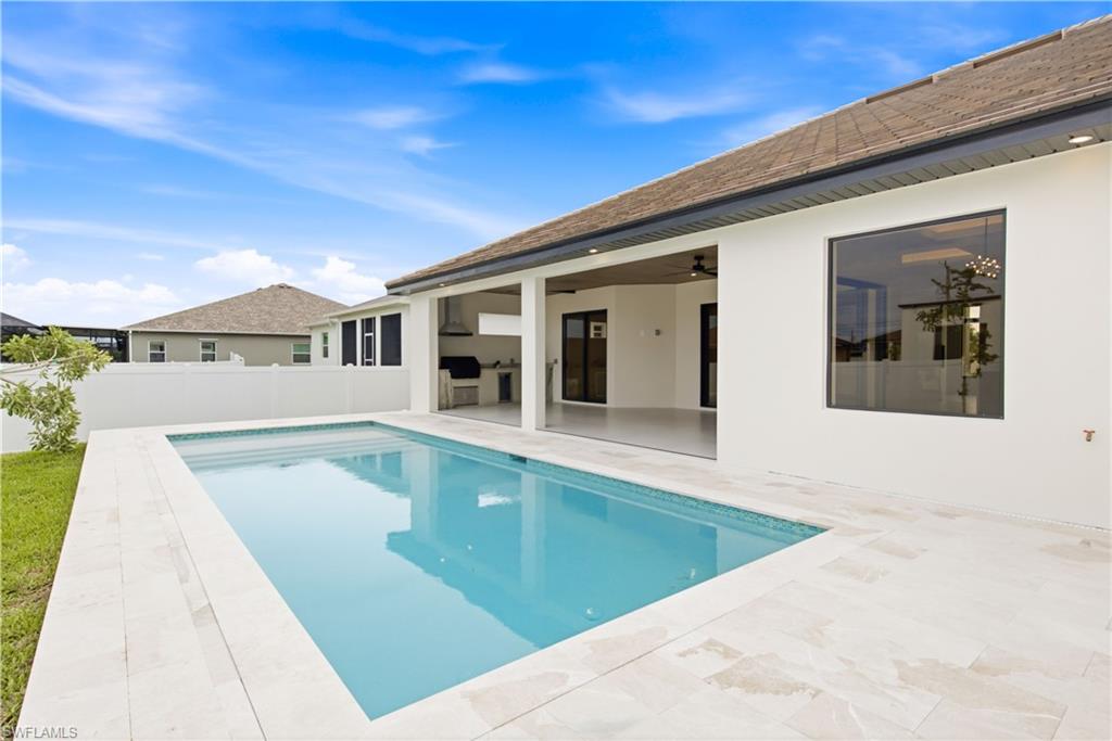 Private pool surrounded by an elegant marble deck creates a serene backyard retreat.