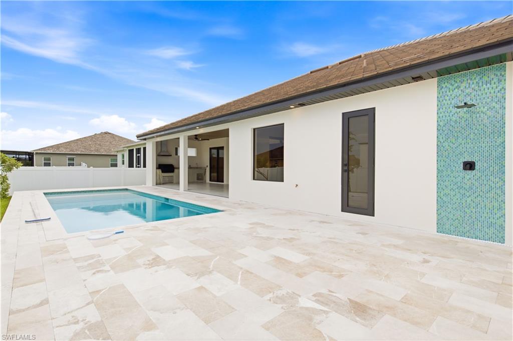 All overlooking sparkling custom pool surrounded by elegant marble decking