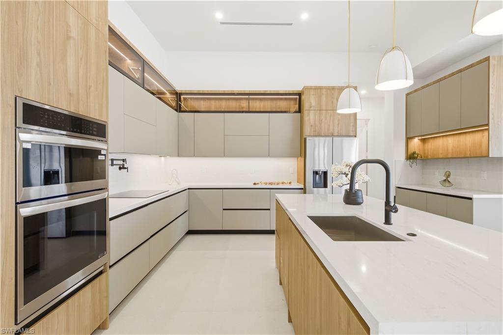 Sleek European-style cabinetry with warm wood accents and integrated LED lighting creates a sophisticated modern aesthetic.