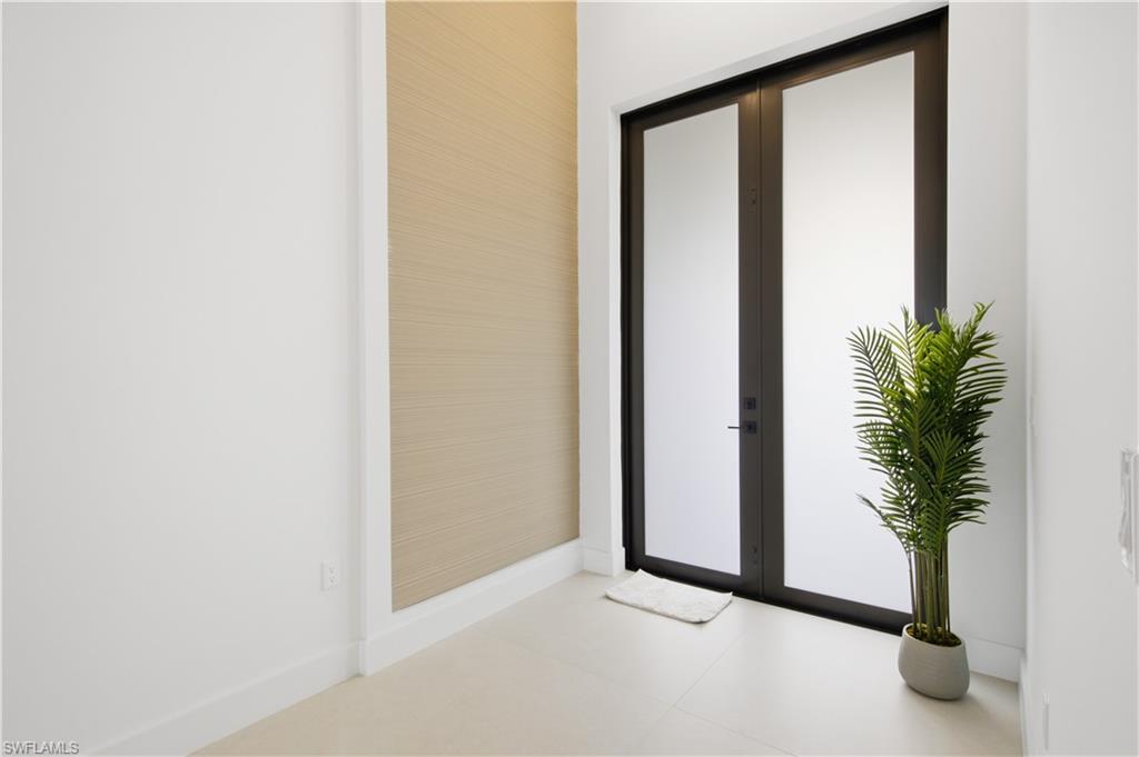 Impressive double-door entry with soaring ceilings creates a bright, modern first impression.