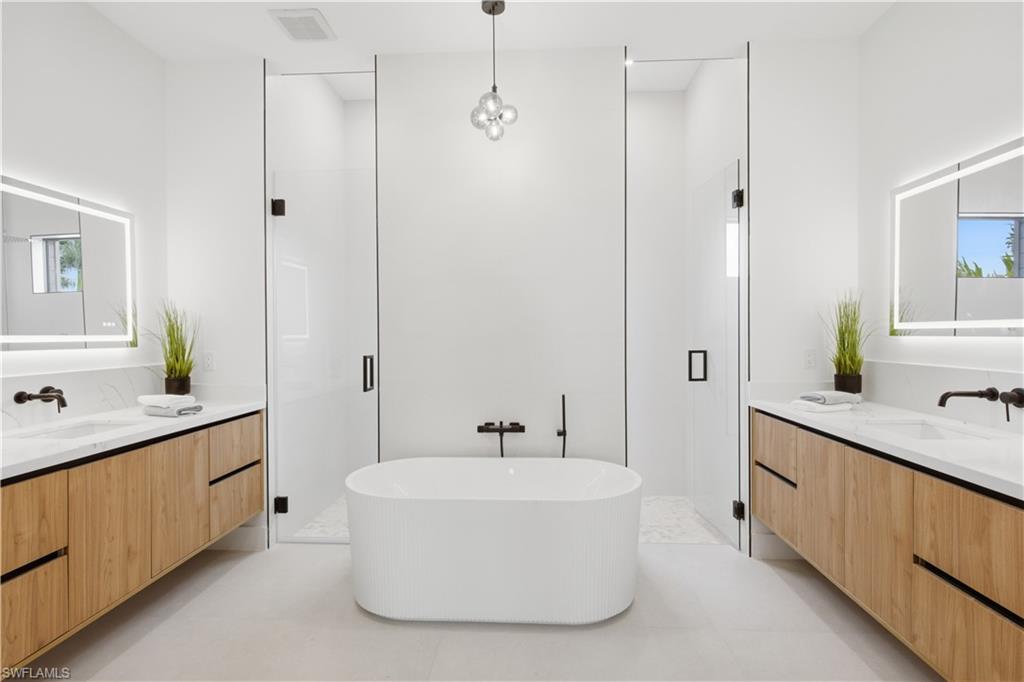 Spa-inspired ensuite w/ freestanding soaking tub, dual floating vanities, LED mirrors