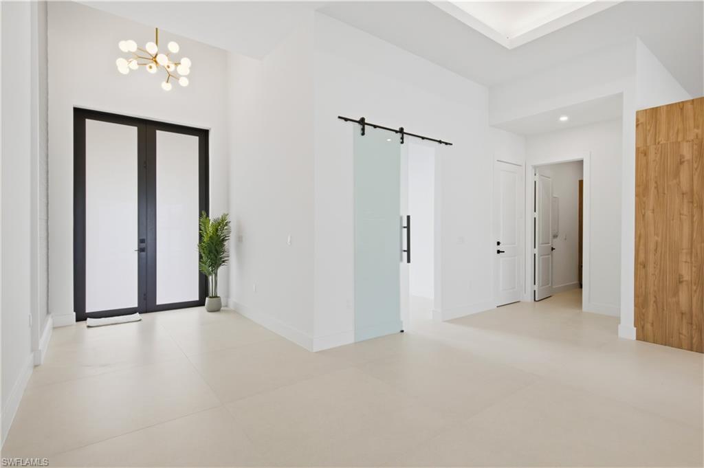 Discover inside w/ 48x48 designer porcelain tile throughout, soaring ceilings w/ tray & wood accents, abundant natural light, impact windows & doors & clean contemporary lines that define every space!