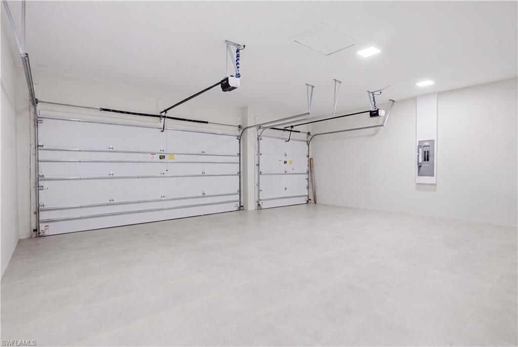 Spacious tiled 3-car garage offers a clean, polished finish with ample room for vehicles and storage.