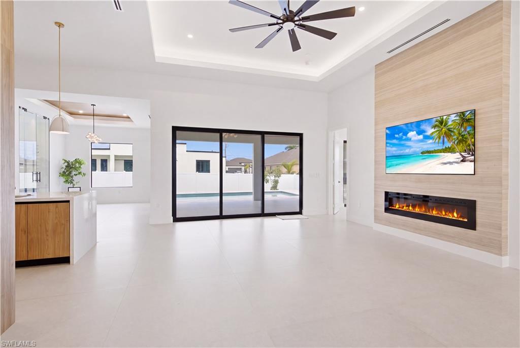Spectacular great room features linear electric fireplace w/ floor-to-ceiling feature wall, creating the perfect gathering space while oversized sliding doors seamlessly blend indoor & outdoor living.