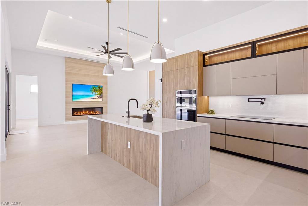 Oversized waterfall island with quartz countertops provides generous prep space and casual seating.