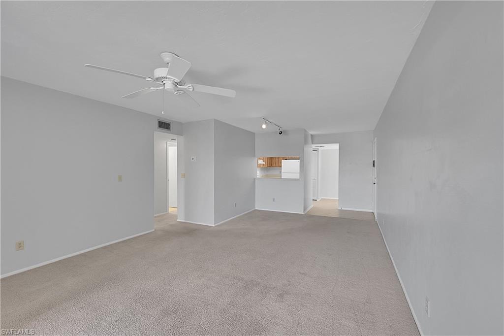 Unfurnished living room with light carpet, ceiling fan, and track lighting