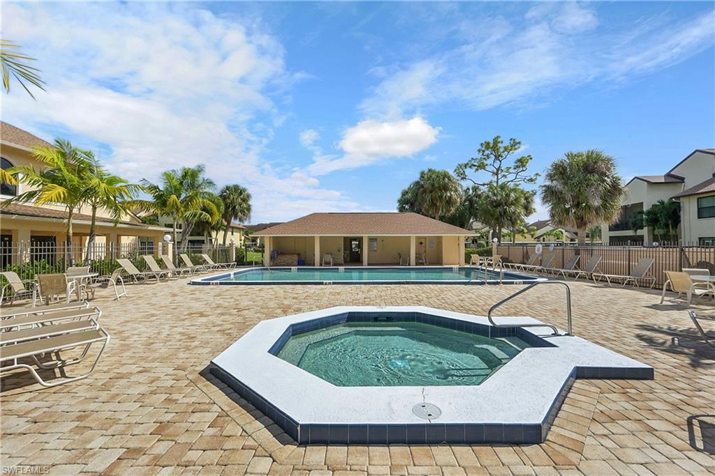 Community pool with a patio and a hot tub