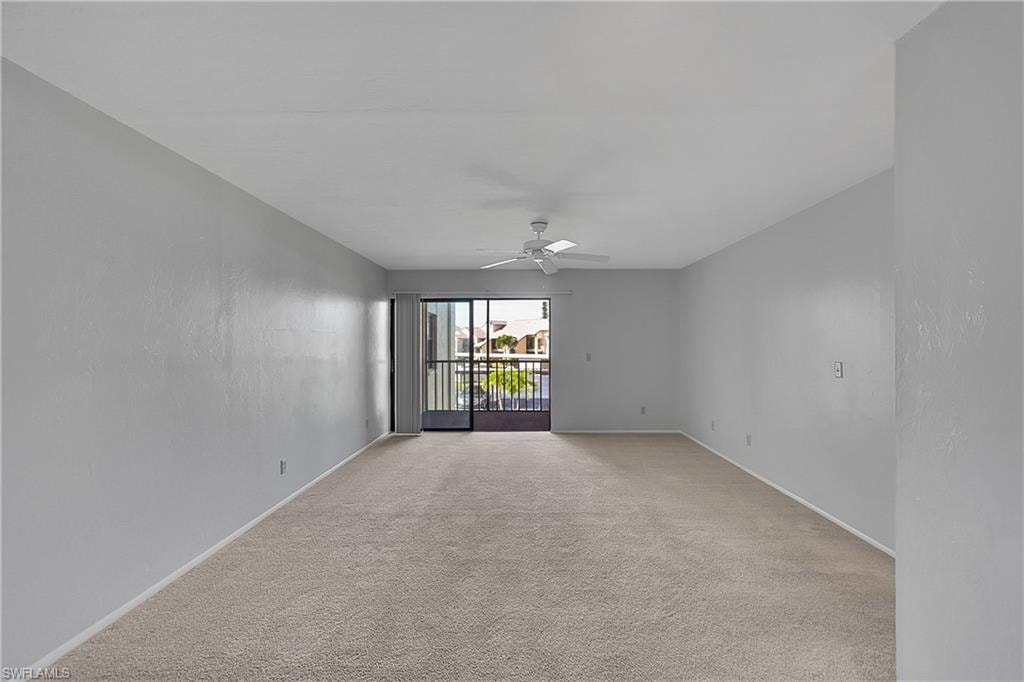 Spare room featuring light colored carpet and a ceiling fan