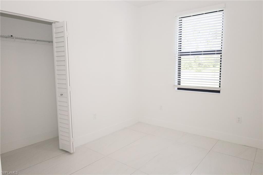 Bright interior space with white walls and large format tile flooring