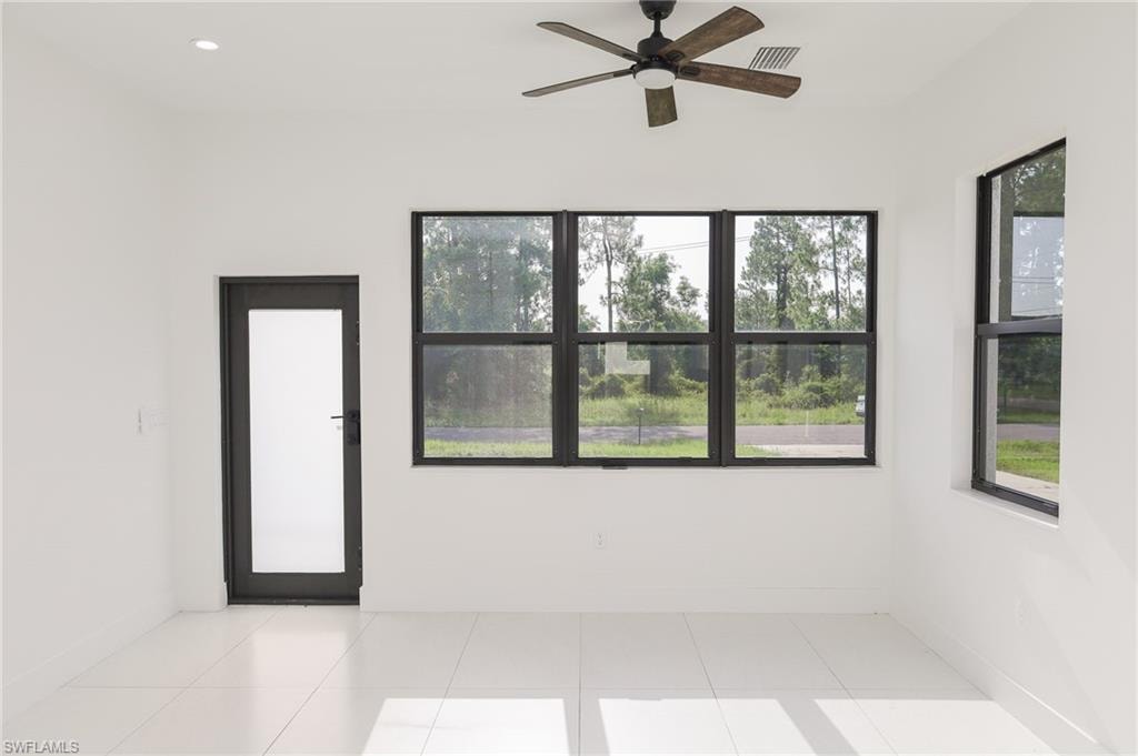 Bright interior space featuring white walls and light-toned tile flooring