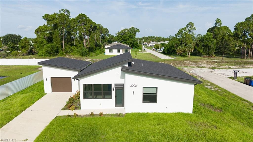 Front of home. Contemporary-style residence featuring a white stucco exterior and a dark shingle roof