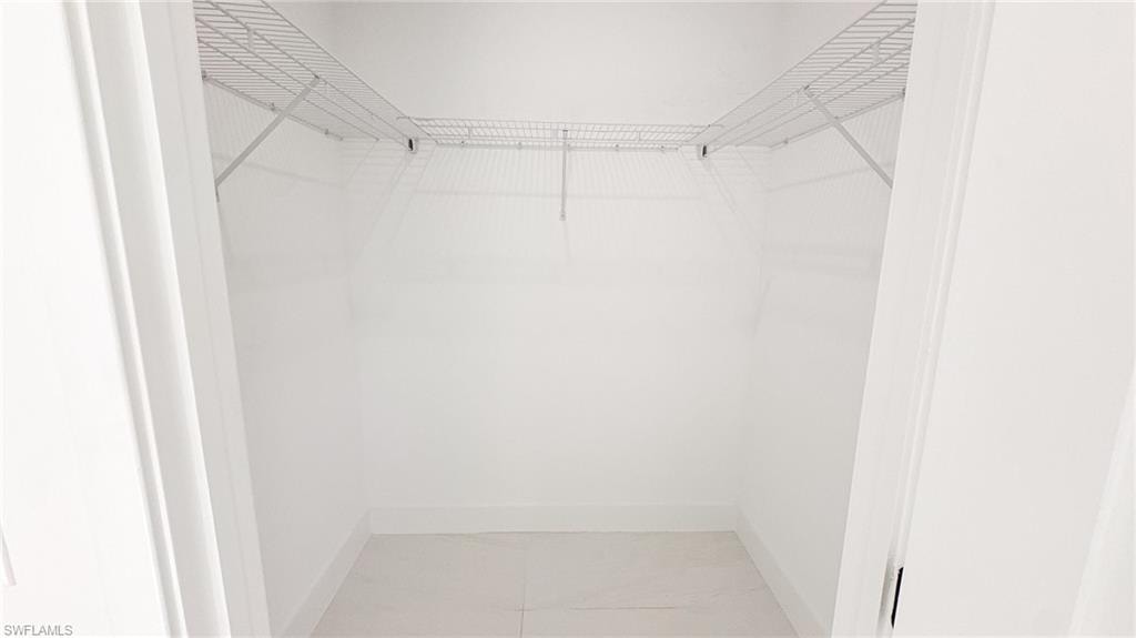Recessed closet featuring white wire shelving, baseboard trim, and light-toned flooring