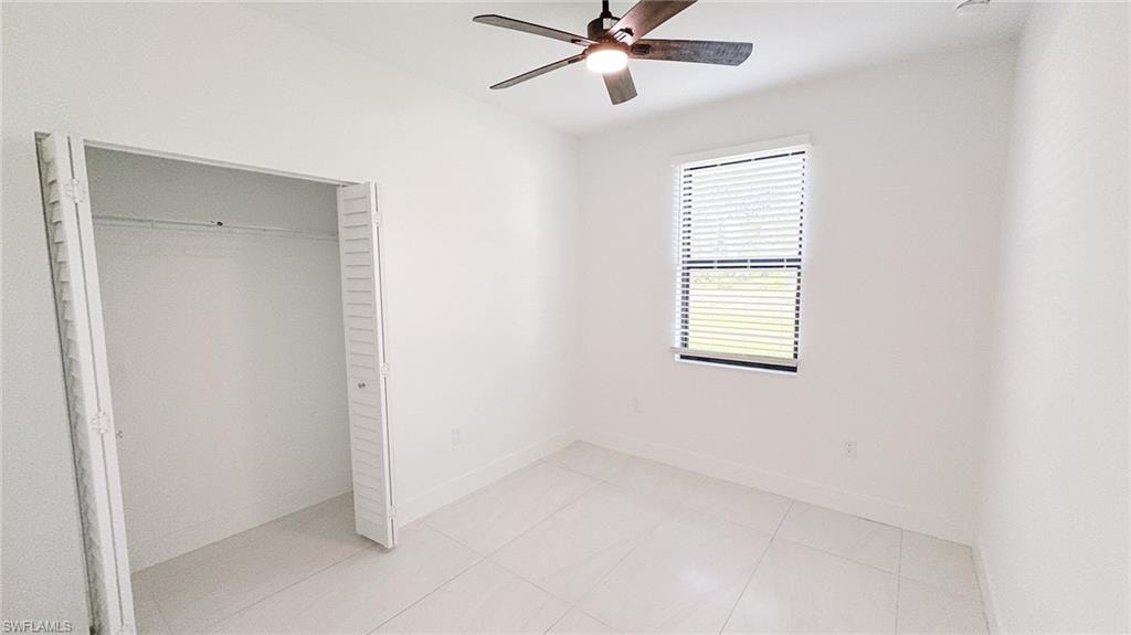 Bedroom featuring white walls and large format tile flooring
