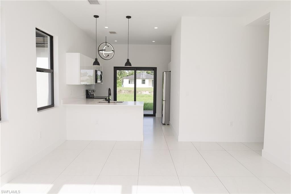 Open-concept living space with large format white tile flooring