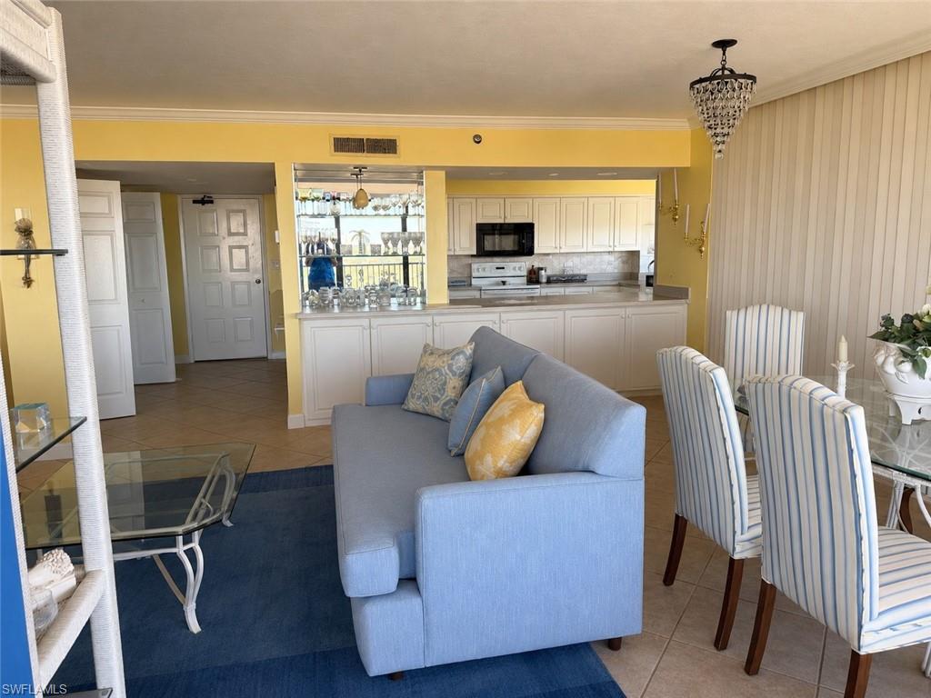 *Enhanced photo Open-concept living space featuring a kitchen with white cabinetry and dark appliances