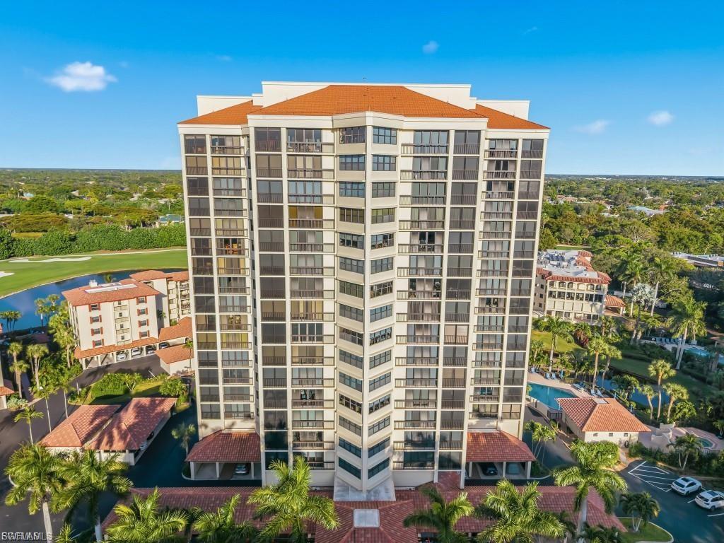 High-rise residential building featuring a red tile roof and multiple balconies
