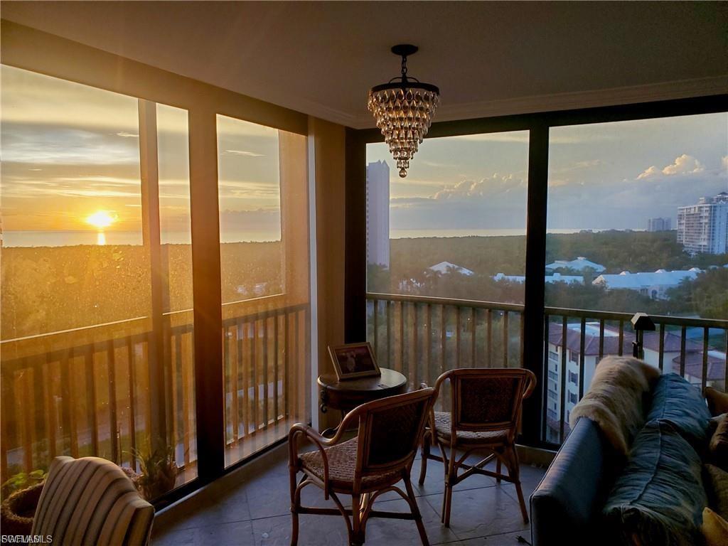 Expansive windows frame a scenic backdrop featuring a body of water and distant structures