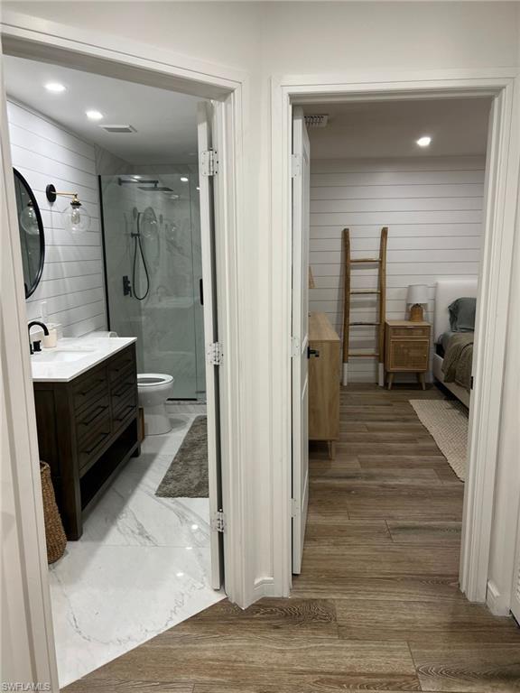 Two distinct spaces featuring wood-finish flooring in the foreground and white shiplap walls