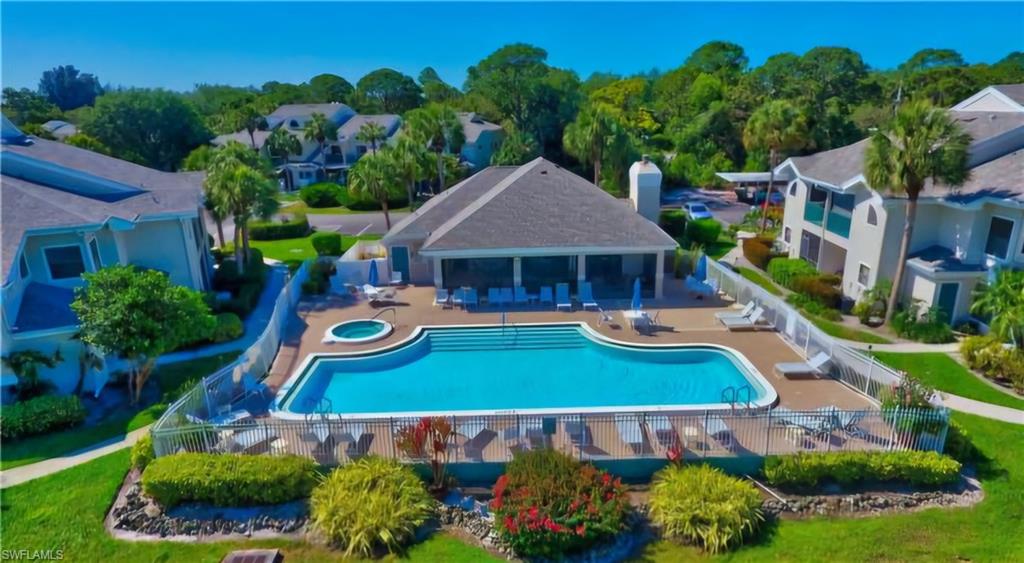Community swimming pool with an integrated spa, surrounded by a paved deck and lounge chairs