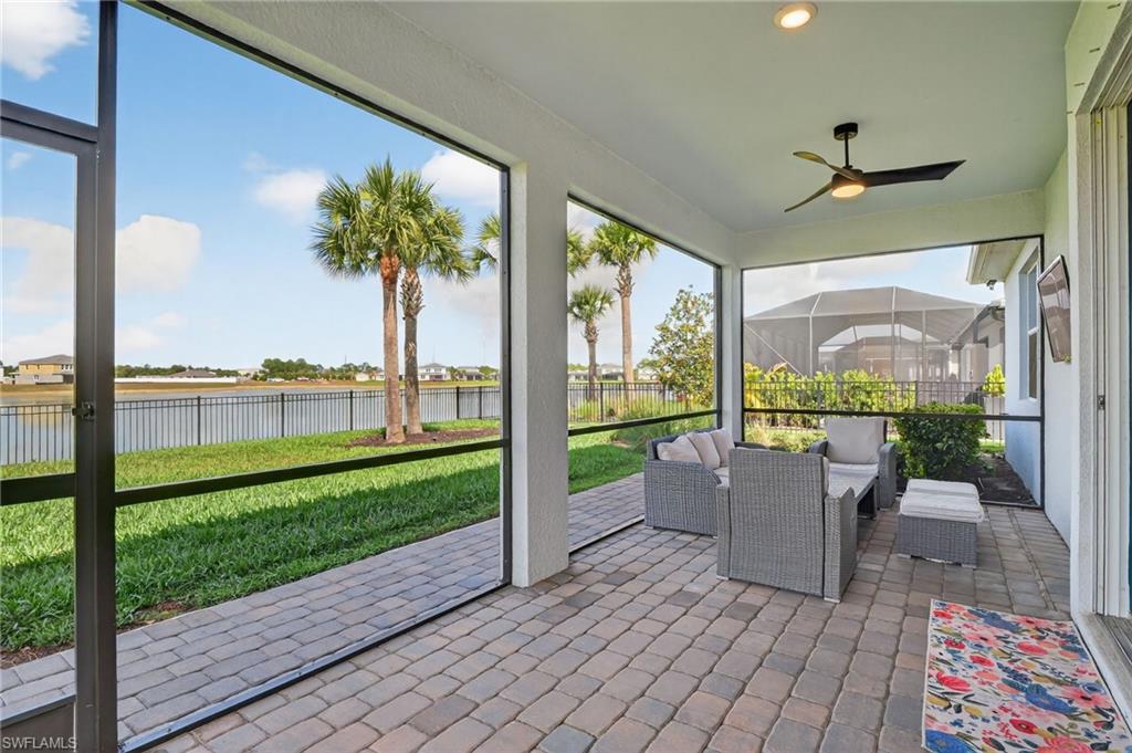 Screened-in patio with paver flooring, overhead lighting, and ceiling fan