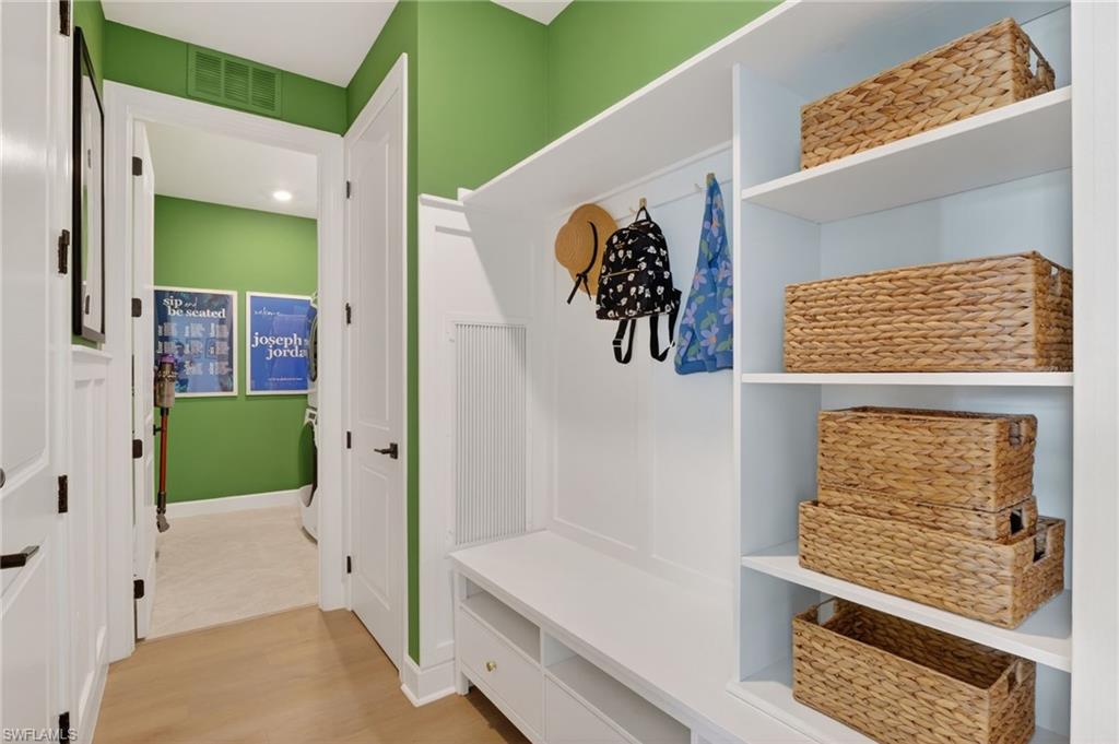Built-in mudroom storage featuring open shelving, integrated bench seating, and storage hooks
