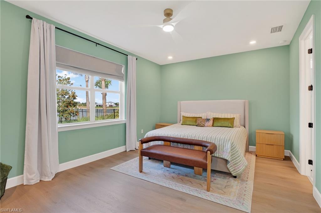 Spacious room featuring light wood-finish flooring, recessed lighting, and a modern ceiling fan