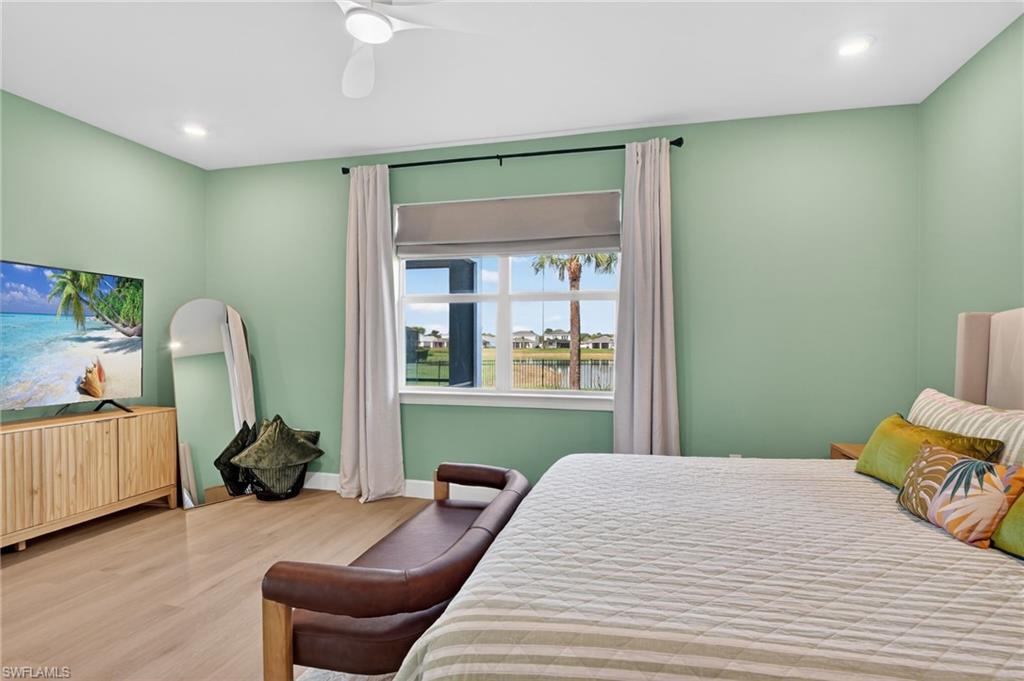 Bedroom featuring light green walls and wood-finish flooring