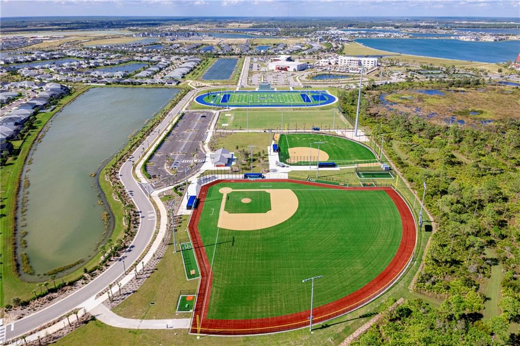 Modern recreation complex featuring multiple baseball fields with manicured turf, a blue track, and an athletic field