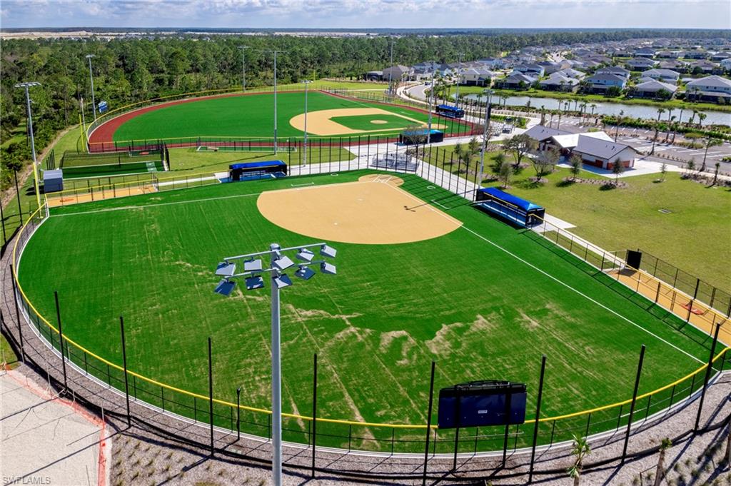 Baseball field featuring artificial turf, a scoreboard, and stadium lighting