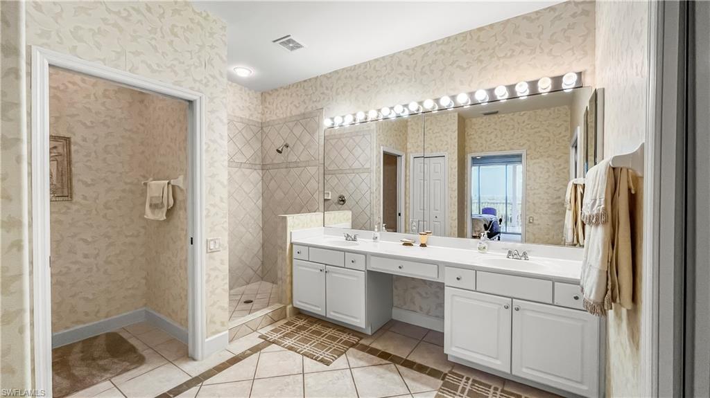 Bathroom with tile patterned floors, vanity, and walk in shower