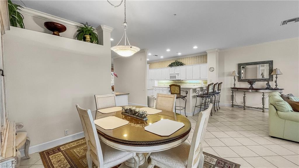 Tiled dining room featuring crown molding