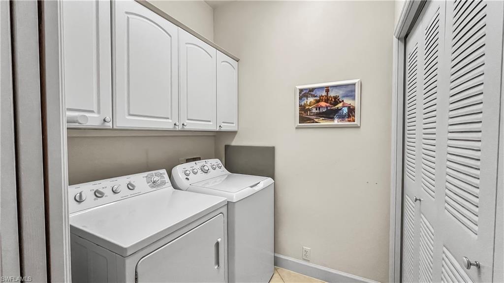 Laundry area featuring cabinets and washing machine and clothes dryer