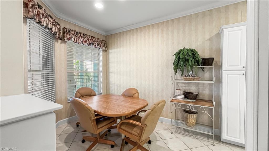 Dining room with crown molding and light tile patterned floors