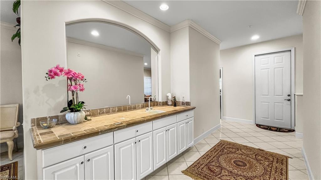Bathroom featuring tile patterned flooring, vanity, and ornamental molding