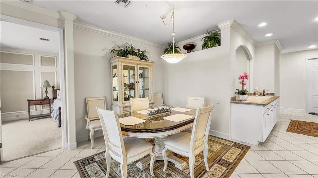Tiled dining room featuring ornamental molding