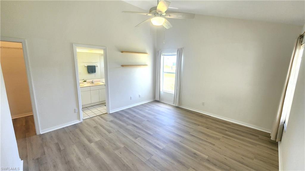 Primary BD with vaulted ceilings and wood-finish flooring