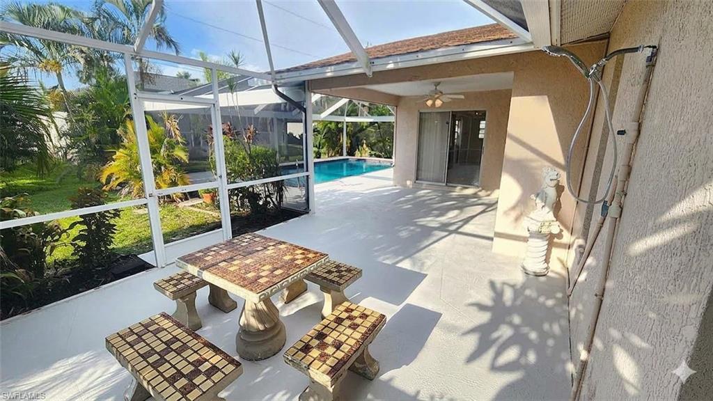 Screened outdoor patio featuring a swimming pool, covered porch, and mature tropical landscaping