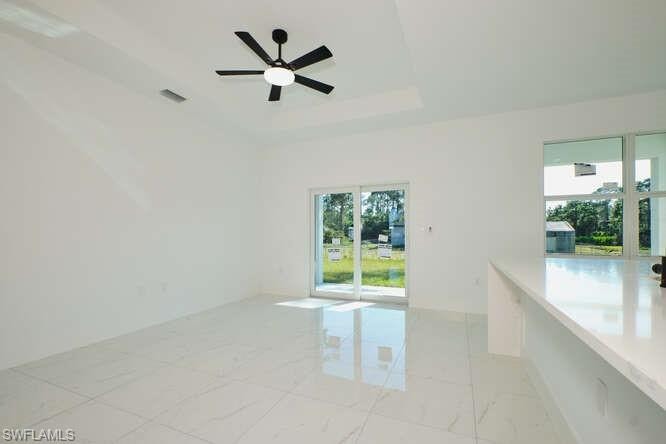 Unfurnished room with a raised ceiling and ceiling fan