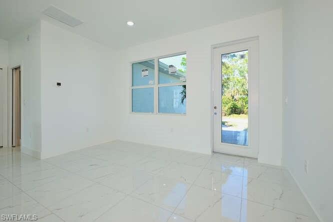 Spare room featuring light marble finish floors and recessed lighting