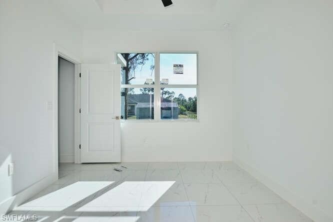 Spare room featuring light marble finish flooring and ceiling fan