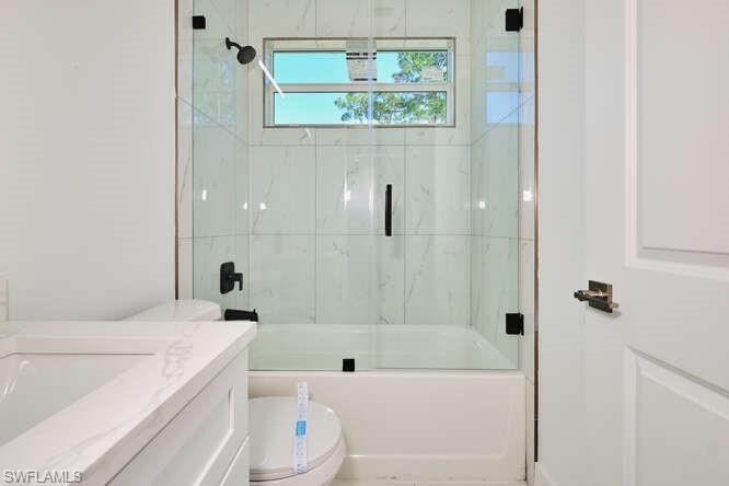 Full bath with combined bath / shower with glass door and vanity
