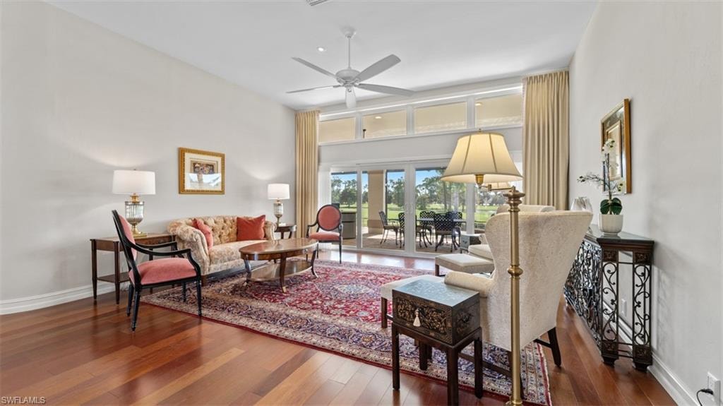 Spacious living area featuring wood-finish flooring, a vaulted ceiling, and an integrated ceiling fan