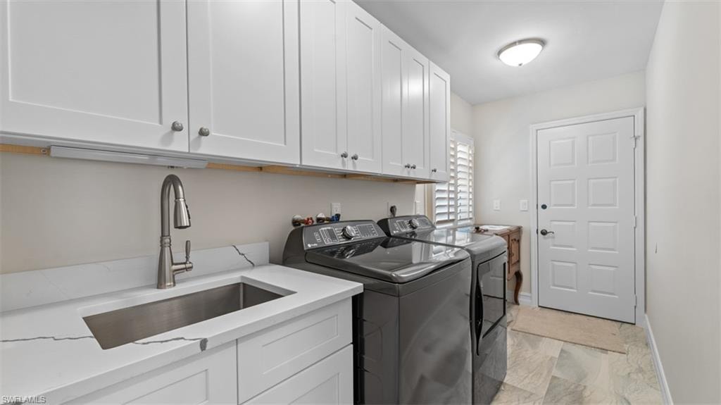 Utility room featuring white shaker-style cabinetry, a stainless steel sink with a gooseneck faucet, light-toned flooring, and plantation shutters