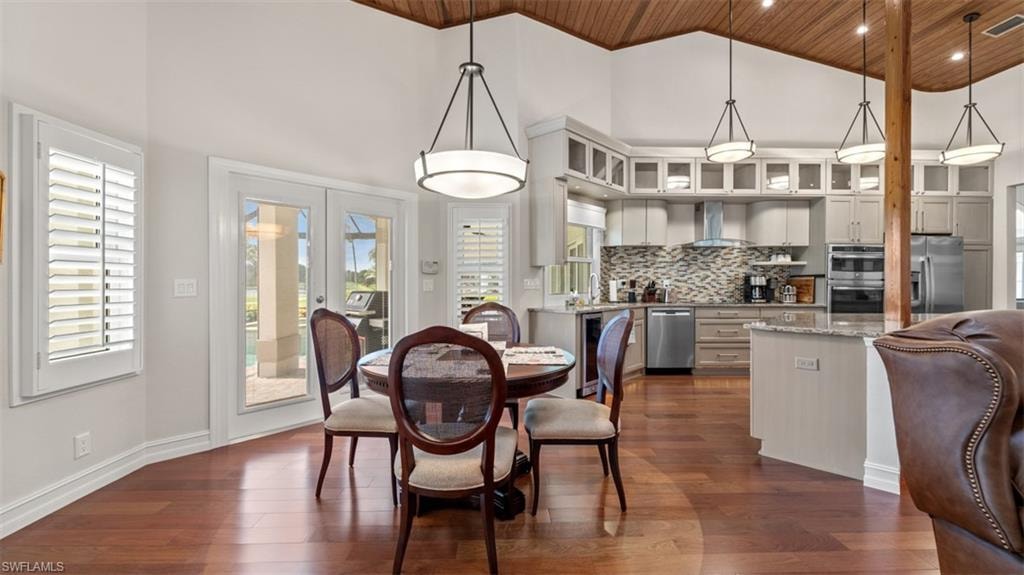 Open-concept living space featuring wood-finish flooring, a vaulted wood-paneled ceiling, and recessed lighting