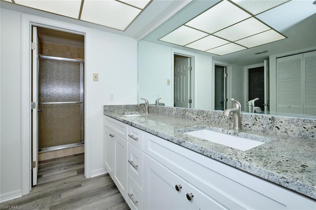 Bathroom featuring a dual vanity with white cabinetry, stone countertops, and undermount sinks