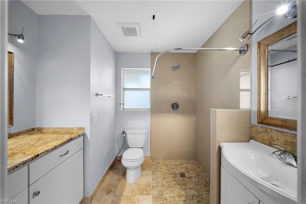 Walk-in shower with light-toned tile, floor-to-ceiling