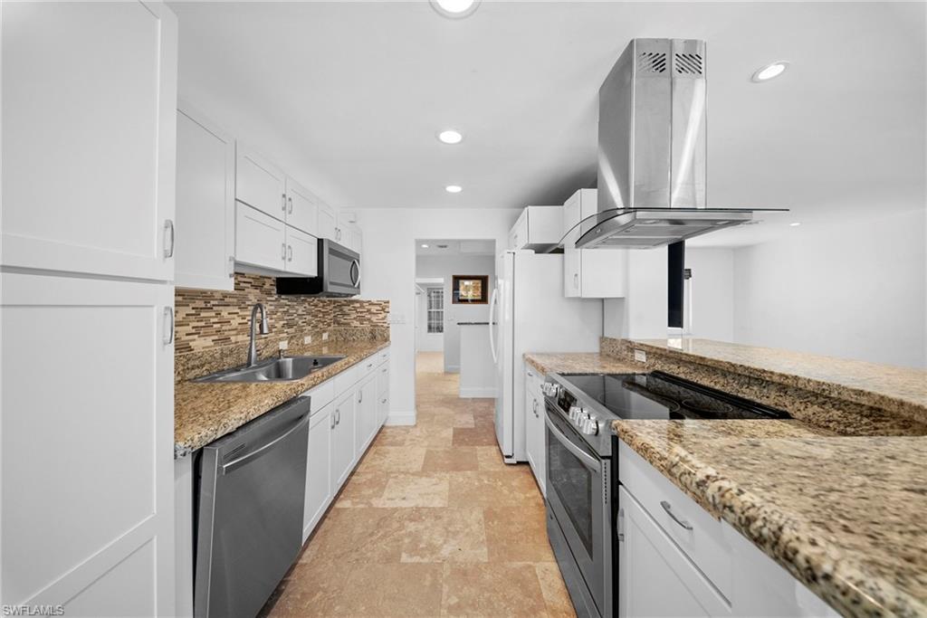 Modern kitchen featuring white cabinetry, granite countertops, and stainless steel appliances