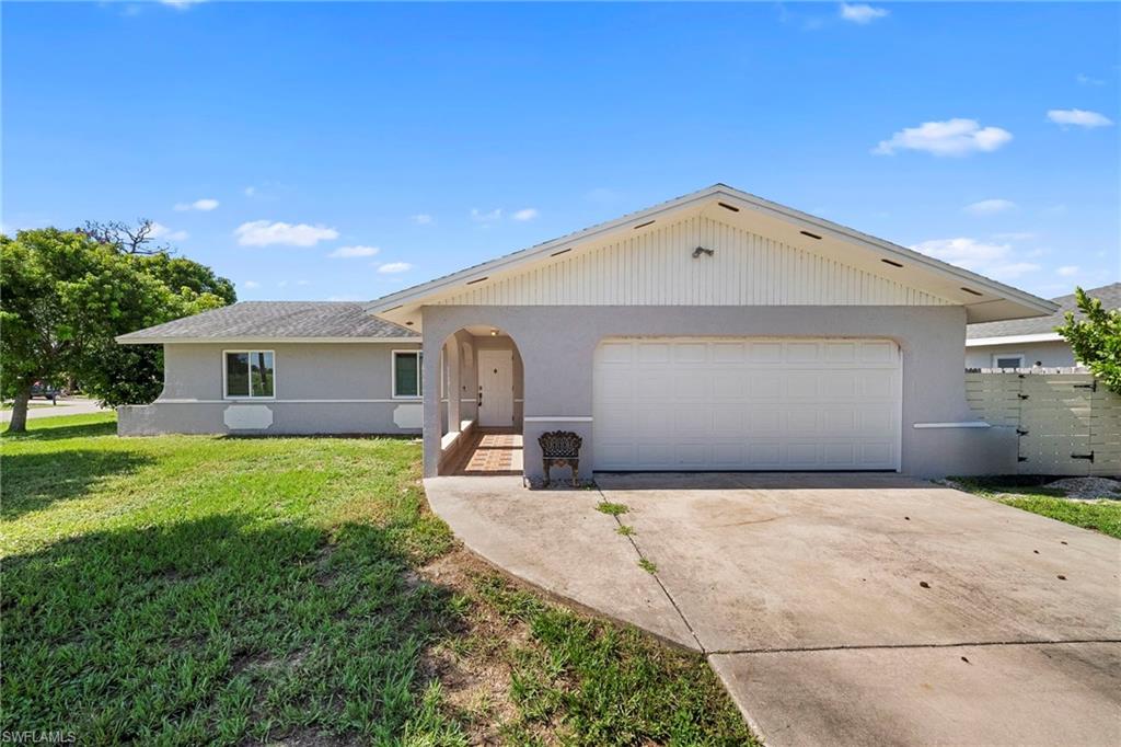 Single-story stucco residence featuring an attached garage and a covered entryway